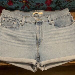 Levi Light Blue Denim Shorts. Ladies size 32 distressed in color  .
